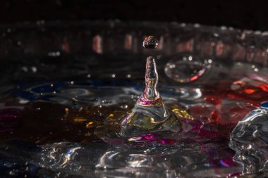 Su damlaları su sıçratarak dalgaları, dalgaları ve soyut su sütunlarını renklendirir.