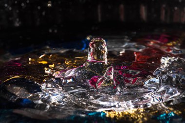 Su damlaları su sıçratarak dalgaları, dalgaları ve soyut su sütunlarını renklendirir.