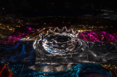 Su damlaları su sıçratarak dalgaları, dalgaları ve soyut su sütunlarını renklendirir.