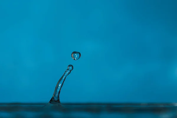 Vatten droppar stänk bildar ringar och vågor och abstrakta vatten kolumner — Stockfoto