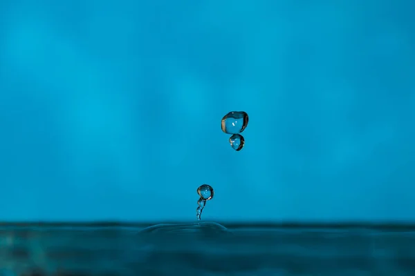 Water drops splash forming ripples and waves and abstract water columns — 스톡 사진