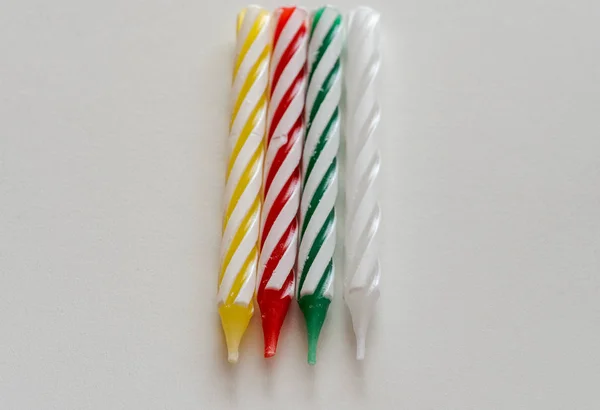 Serie di candele colorate a strisce su sfondo bianco — Foto Stock