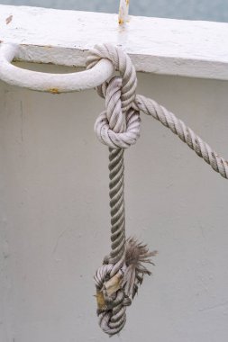 Beyaz paslı arka planı olan kalın beyaz ipten yapılmış denizci düğümü