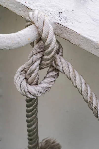 Матросский узел из толстой белой веревки на белом ржавом фоне — стоковое фото