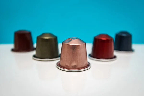 colorful coffee capsules arranged with a blue background