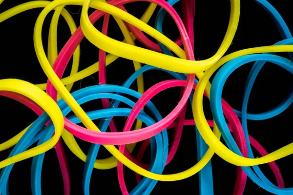 Pile of colorful small rubber bands isolated on a black back ground — Stock Photo, Image