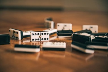 Kahverengi turuncu tahta zemindeki domino taşları rastgele 6: 6 domino jetonuna odaklanmış.