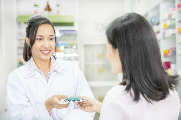 Фармацевт и клиент в аптеке — стоковое фото