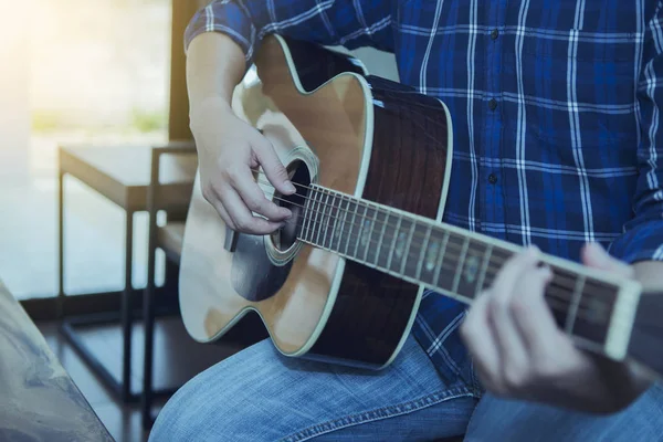 close up  of a man playing guitar indoor