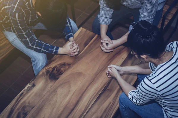 Hıristiyanlar ahşap bir masanın etrafında birlikte dua ederler. Dua toplantısı, küçük grup konsepti..