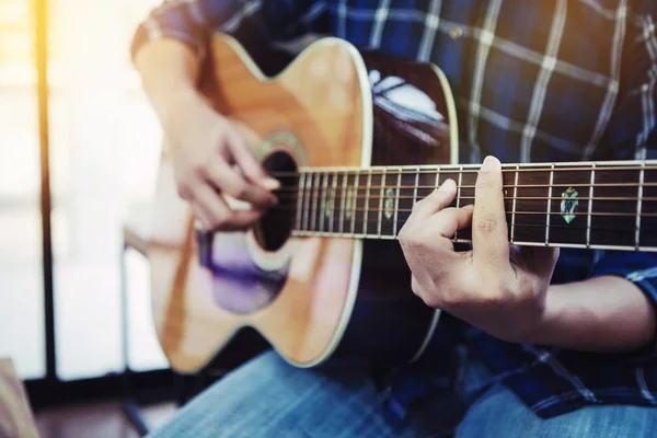 Yuvada gitar çalan bir adamın ellerini kapat.