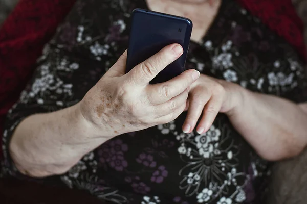 나이든 여자의 아름다운 손이죠 얼굴에 노인의 스마트폰을 만지고 있습니다 — 스톡 사진