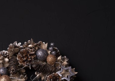 Yıldızlar, toplar ve çıkıntılarla süslenmiş Noel çelengi.