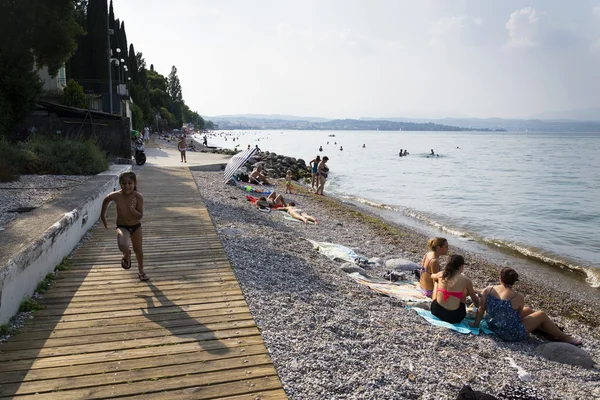 Personas tomando el sol en la playa el 30 de julio de 2016 en Desenzano del Garda, Italia . — Foto de Stock