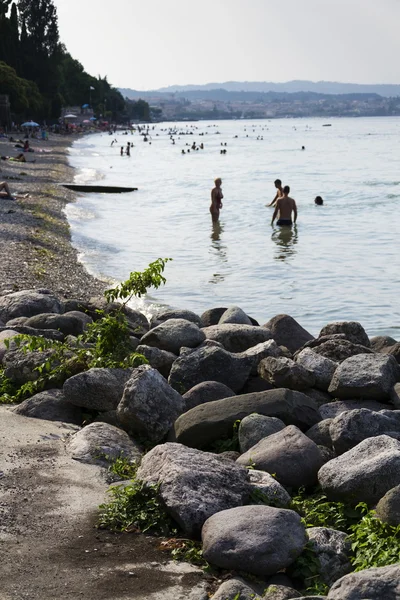 Menschen sonnen sich am Strand am 30. Juli 2016 in Desenzano del Garda, Italien. — Stockfoto