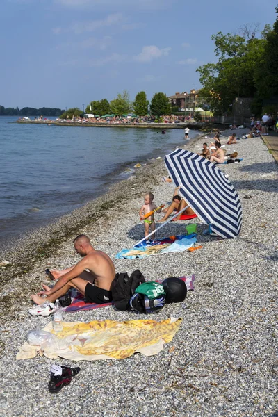 People sunbathing on beach on 30 July 2016 in Desenzano del Garda, Italy. — Stock Photo, Image