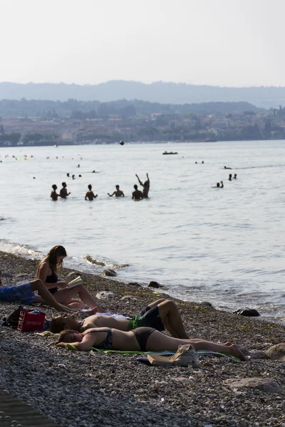 Lidé, opalování na pláži na 30 července 2016 v Desenzano del Garda, Itálie. — Stock fotografie