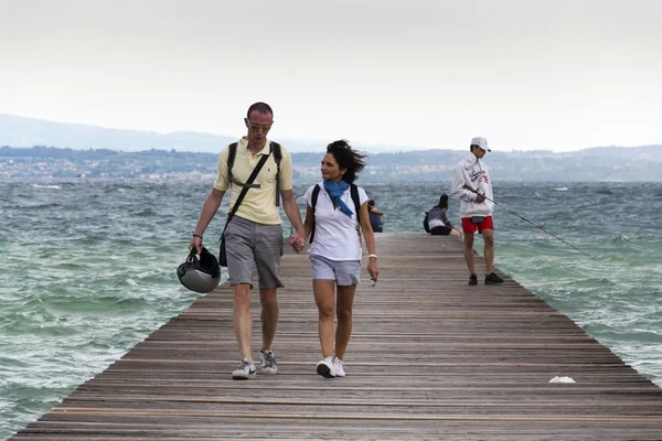 Lidé na dřevěném molu na Lago di Garda na 31 červenci 2016 v Sirmione, Itálie. — Stock fotografie