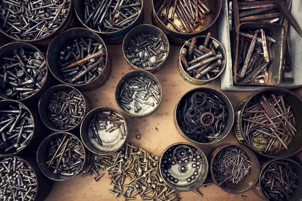 筛选的螺钉和螺栓在锡罐上木制背景 — 图库照片