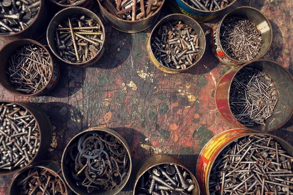 铁钉和螺钉在生锈的锡罐上木制背景 — 图库照片