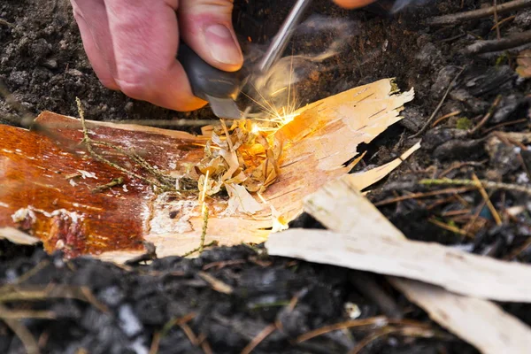Mannenhand begint brand met magnesium brand staal, vuur spits — Stockfoto
