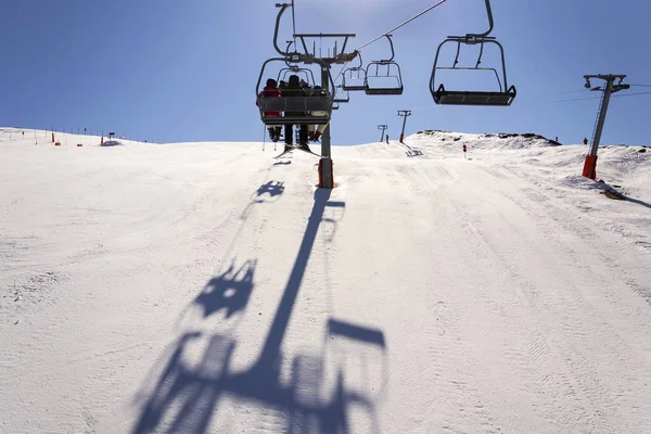 在阳光灿烂的冬天的阿尔卑斯山，非盟滑雪缆车的人 — 图库照片