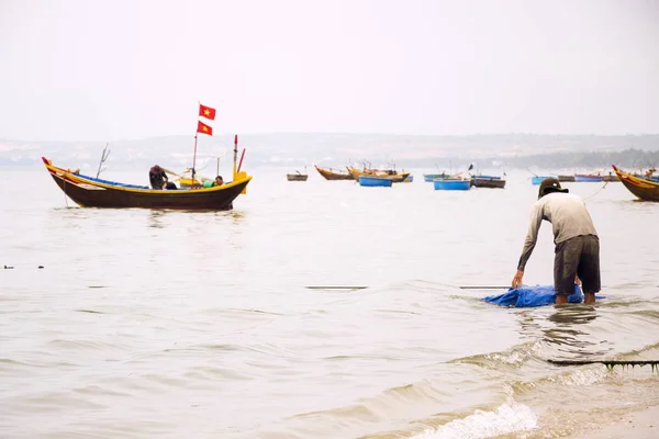 Pescadores com barcos de pesca coloridos em 7 de fevereiro de 2012 em Mui Ne, Vietnã . — Fotografia de Stock