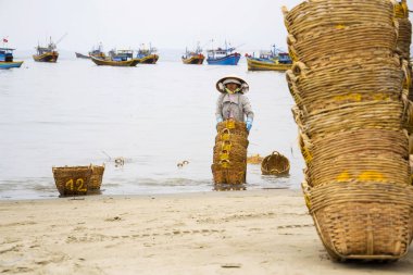 7 Şubat 2012 yılında MUI Ne, Vietnam üzerinde balık sosu için kullanılan hamsi için sepetler yıkama kadın.
