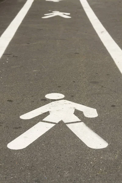 Sinal de pavimento homem andando pintado de branco no caminho concreto — Fotografia de Stock
