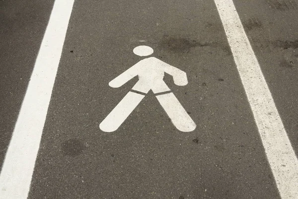 Sinal de pavimento homem andando pintado de branco no caminho concreto — Fotografia de Stock