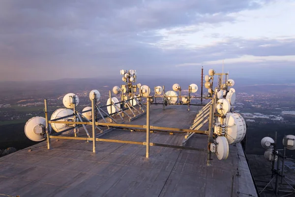 Bos van zenders en antennes op de telecommunicatie toren tijdens zonsondergang — Stockfoto