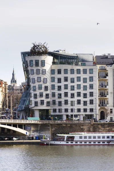 Boat floating in front of the Dancing House, nicknamed Fred and Ginger, completed in 1996 for Nationale-Nederlanden by Vlado Milunic and Frank Gehry on March 3, 2017 in Prague, Czech republic. — Stock Photo, Image