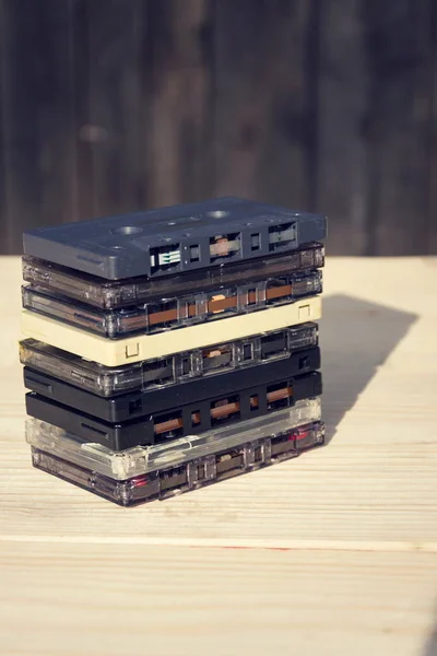 Fitas magnéticas de áudio cassete compactas retro filtradas em fundo de madeira — Fotografia de Stock