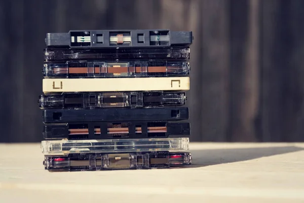 Gefilterde retro compact cassette audio magneetbanden op houten achtergrond — Stockfoto