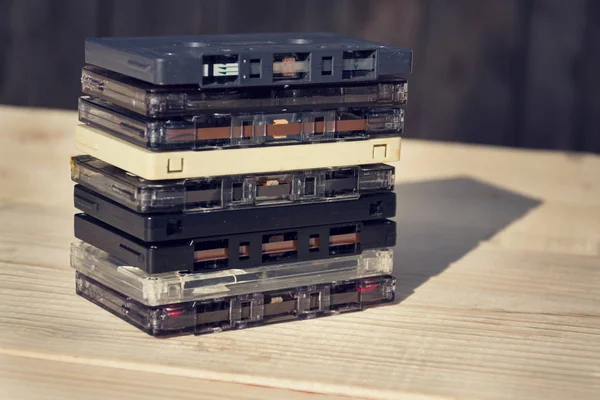 Gefilterte Retro-Kompaktkassetten-Audio-Magnetbänder auf Holzhintergrund — Stockfoto