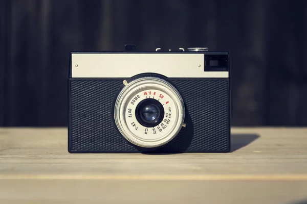 Velho vintage câmera filtrada no fundo de madeira — Fotografia de Stock