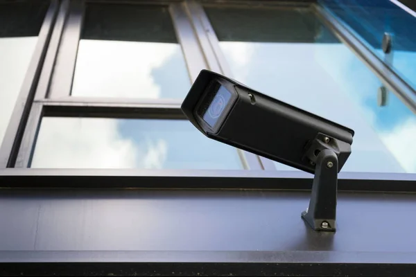 Cámara de seguridad gris con ventana que refleja nubes azules del cielo — Foto de Stock