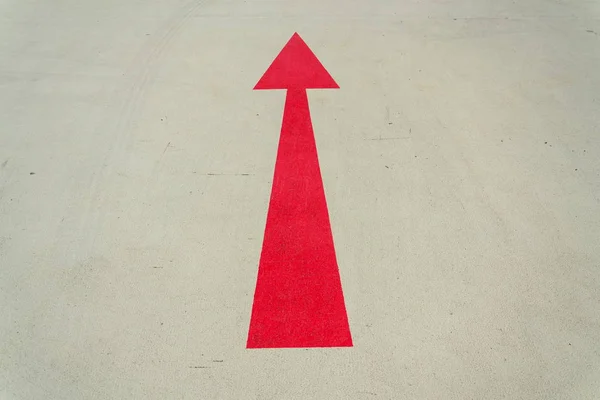 Sinal de direção seta vermelha na estrada de concreto cinza dia ensolarado — Fotografia de Stock