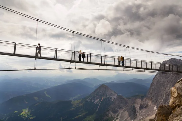 Turystów spacer po moście zawieszenia najwyższej Austrias Dachstein wiszący most na 17 sierpnia 2017 w Ramsau am Dachstein, Austria. — Zdjęcie stockowe
