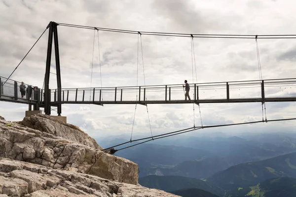 Turystów spacer po moście zawieszenia najwyższej Austrias Dachstein wiszący most na 17 sierpnia 2017 w Ramsau am Dachstein, Austria. — Zdjęcie stockowe