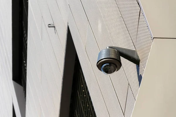 Moderne beveiliging camera gekoppeld aan muur met ramen in achtergrond — Stockfoto