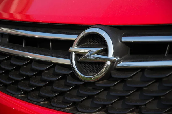 Logotipo de la empresa Opel en el coche frente al edificio del concesionario — Foto de Stock