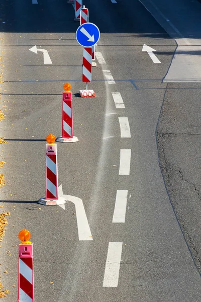 Costruzione di posti di blocco rossi e bianchi con indicazioni stradali, giornata di sole — Foto Stock