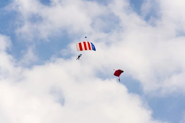 Two parachutists skydiving with colorful parachute clouds blue sky background — Stock Photo, Image