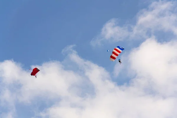 Two parachutists skydiving with colorful parachute clouds blue sky background — Stock Photo, Image