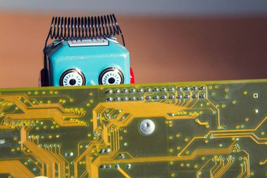Turuncu bilgisayar devre kartı, yapay zeka kavramı saklanıyor vintage teneke oyuncak robot