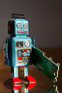 Kızgın vintage teneke oyuncak robot yeşil bilgisayar devre kartı, yapay zeka kavramı taşır