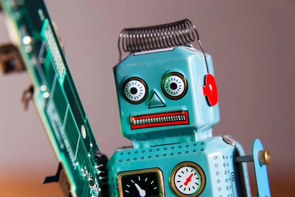 Angry Vintage Tin Toy Robot Carries Green Computer Circuit Board — Stock Photo, Image