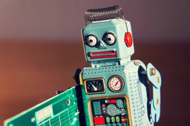 Kızgın vintage teneke oyuncak robot yeşil bilgisayar devre kartı, yapay zeka kavramı taşır