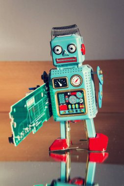 Kızgın vintage teneke oyuncak robot yeşil bilgisayar devre kartı, yapay zeka kavramı taşır
